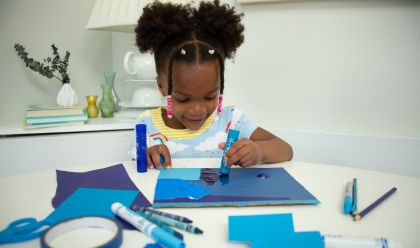 Image of young girl doing an arts and craft project at a dining room table